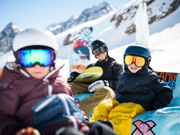 Kinder machen eine Pause vom Snowboarden und Skifahren
