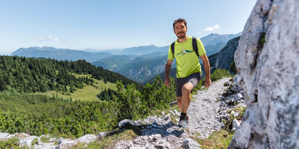 Ein Wanderer in den Bergen mit Short und T-Shirt von Schöffel
