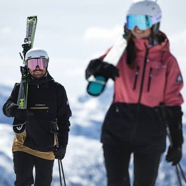 Zwei Skifahrer tragen ihre Ski auf der Schulter