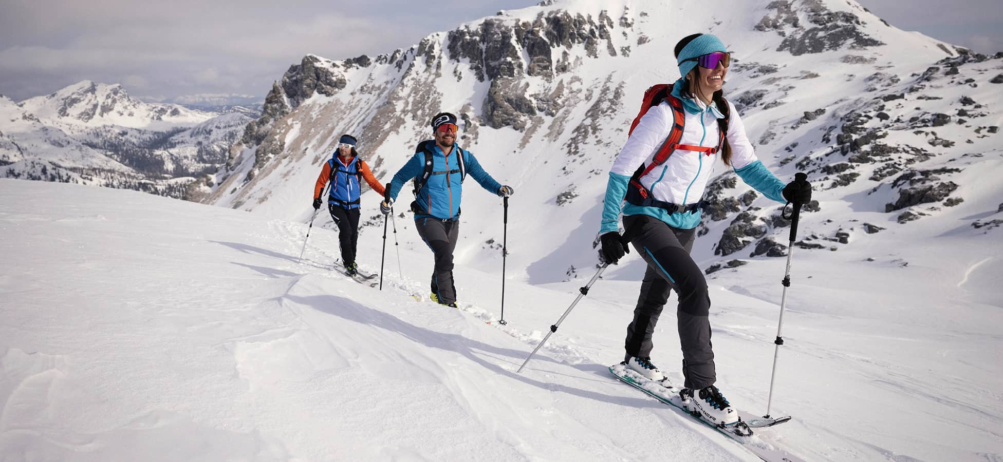Skitourengeher:innen im verschneiten Gebirge